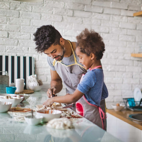 father and child making breakfast