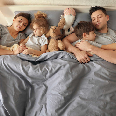 family sleeping in the bed