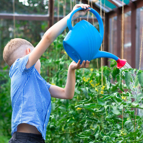 child watering garden plants