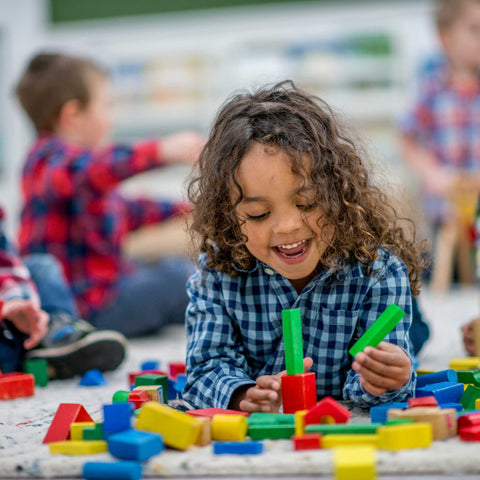 kids laughing and playing with building blocks