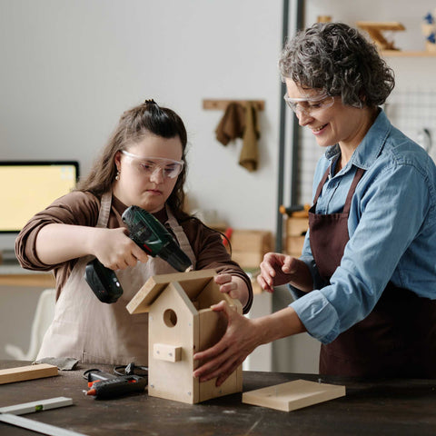 girl building a ird house with instructor