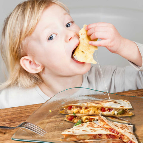 kid eating and cheese and vegetable quesadilla