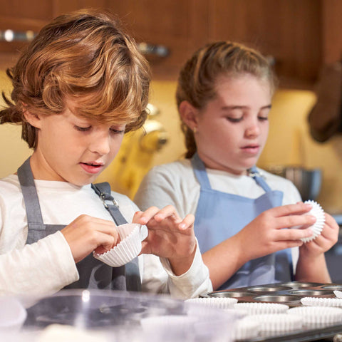 kids lining muffin pans