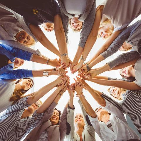 women linking hands in a circle