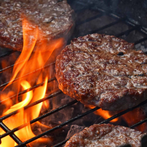cooking burgers on a fire grill