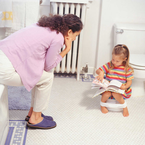 mom and daughter potty training in bathroom