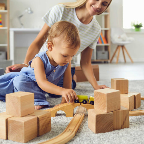 mom and baby playing with train