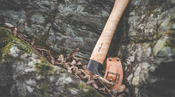 Roselli handmade Finnish outdoor axe laying in the woods with leather sheath  