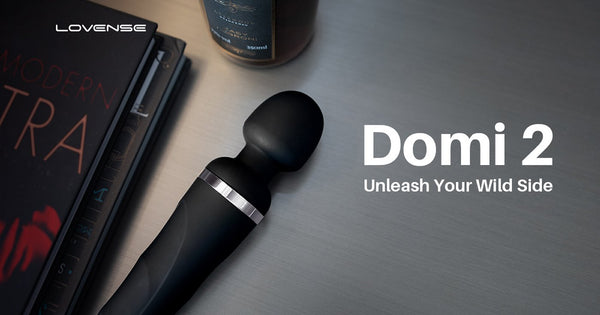 Decorative header image reads: "Domi 2: Unleash your Wild Side". It shows the Domi 2 sitting out in a dimly lit, black table with sex positioning books and a bottle of lube. Everything looks sultry and sexual.