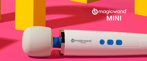 Decorative image for the start of the Vibratex Magic Wand Mini product description. The image shows the Mini sitting in front of a pink background with yellow geometric shapes in the background. The text says "Magicwand MINI".
