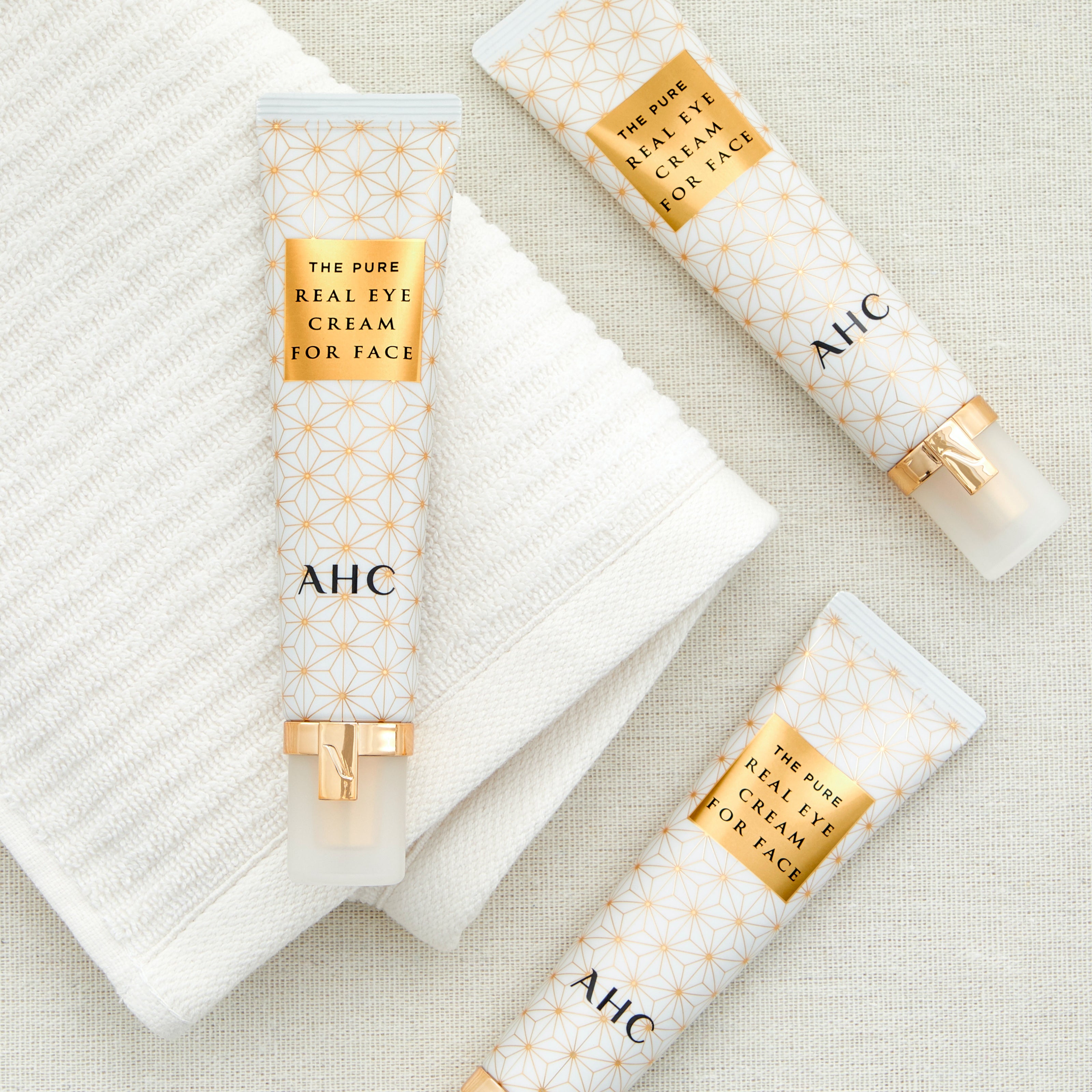 A packshot of AHC pure real eye cream for face on a gold background