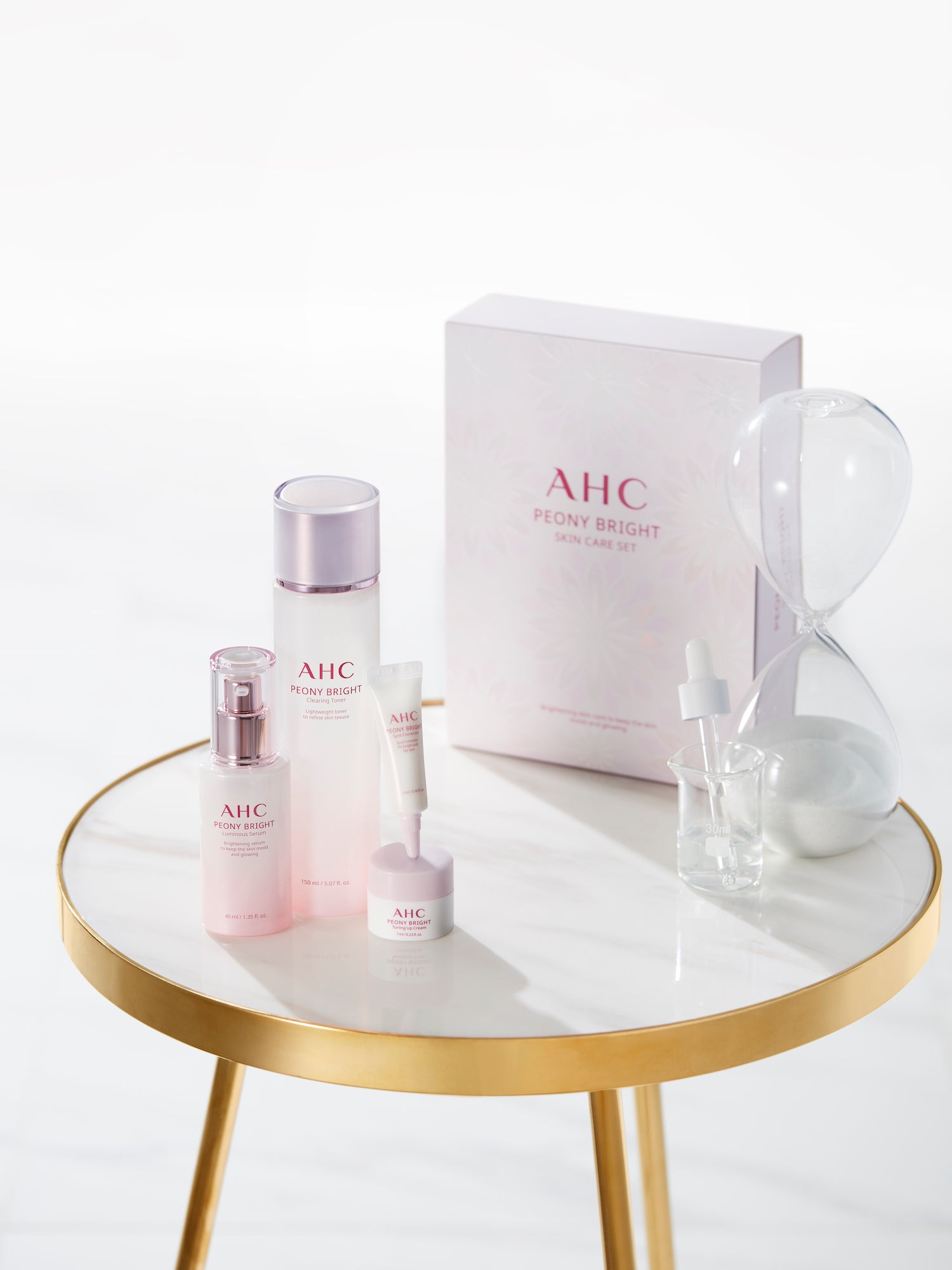 A packshot of AHC peony beauty luminous range on a marble table.