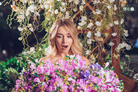 A woman holds a bouquet of flowers, representing the different scents that can be used to create the perfect perfume combination.