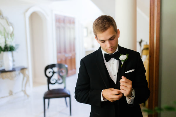 Groom is wearing a black tuxedo and bowtie from Men's Wearhouse.