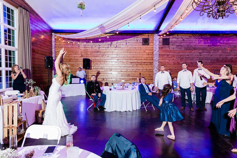 Bride throwing her bouquet to a crowd of women