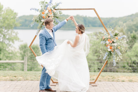 Bride and Groom twirling beneath a floral decorated pergola. 