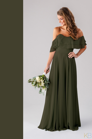 Model in Kennedy Blue Bridesmaid Dress "Allison" in 'Olive Green'. Boho-chic style dress with off-the-shoulder flutter sleeves and a flowy skirt.