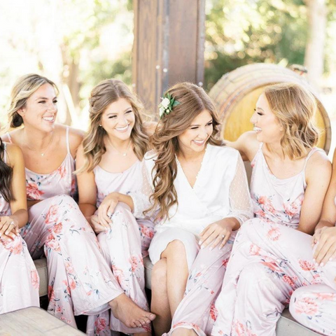 Bride and Bridesmaids wearing matching long floral jumpsuits. 