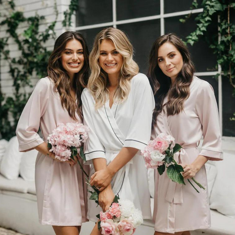 Bride and Bridesmaids wearing satin robes with piping detail.