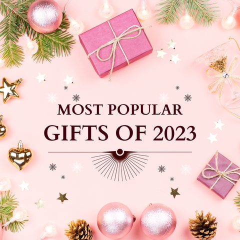 Most Popular Gifts of 2023 on pink background with christmas gifts and bulbs and decor
