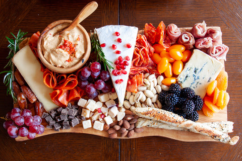 Large charcuterie board with cheeses, meats, veggies