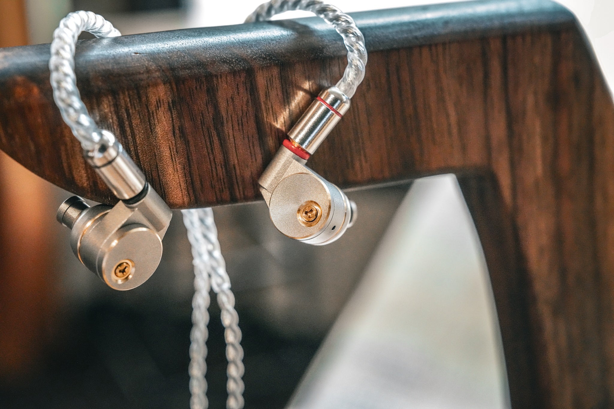 Ucotech RE-2 hanging from a dark stained wooden headphone stand from the Bloom Audio gallery