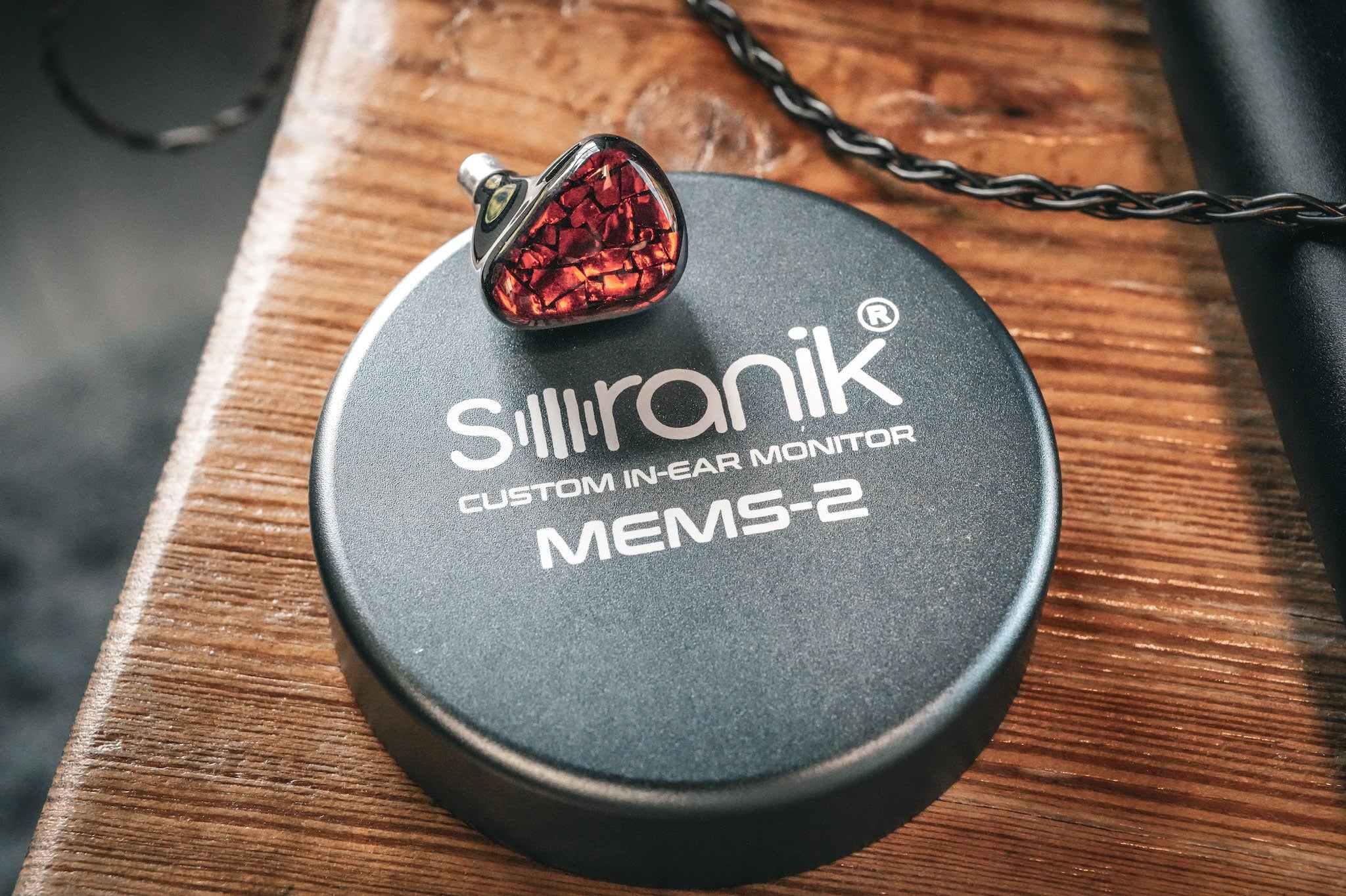 MEMS-2 IEM on top of a Soranik aluminum case resting on top of a wooden stool from the Bloom Audio Gallery