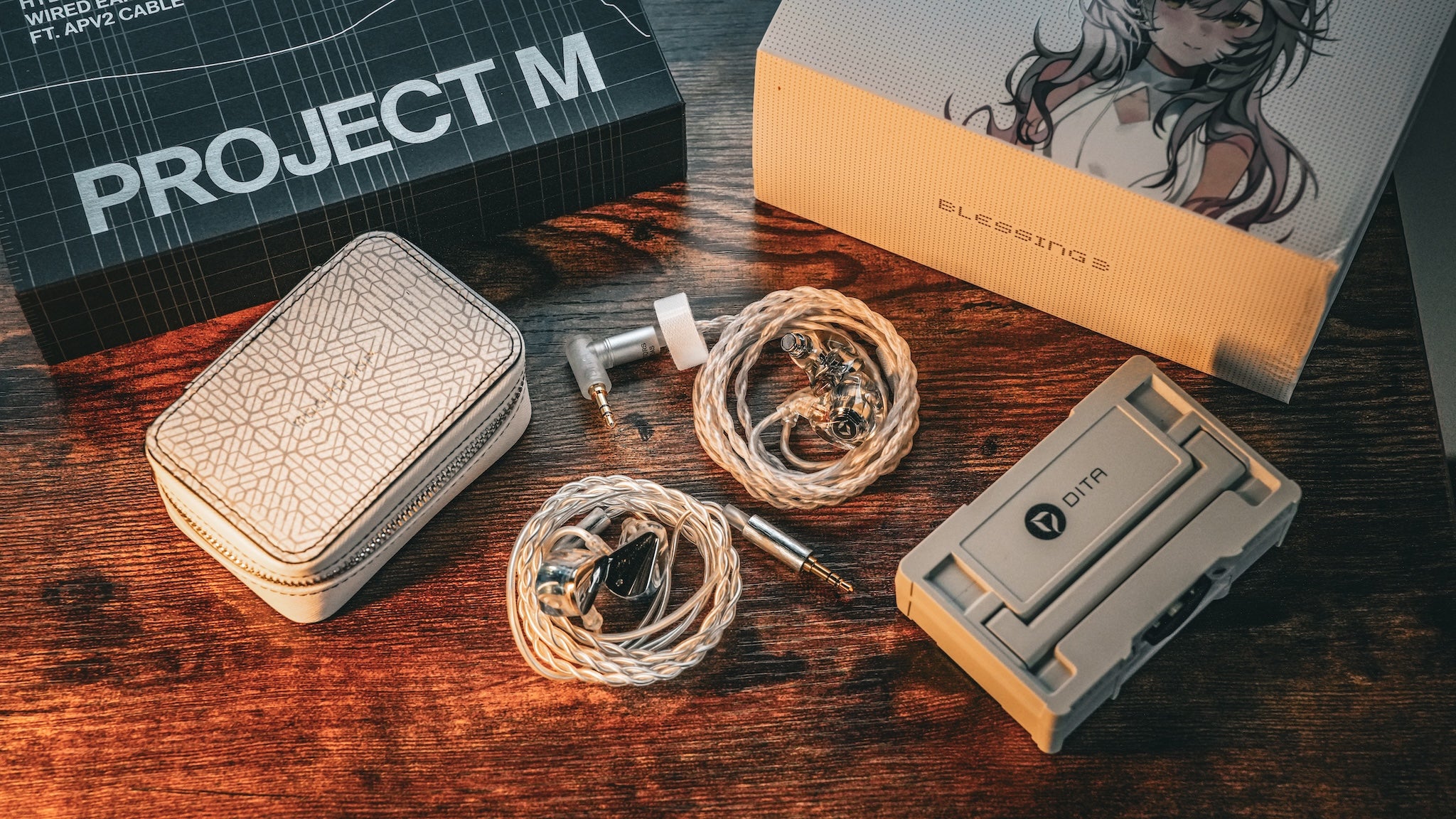 DITA Audio Project M and Moondrop Blessing 3 with associated accessories and packaging over wood backdrop