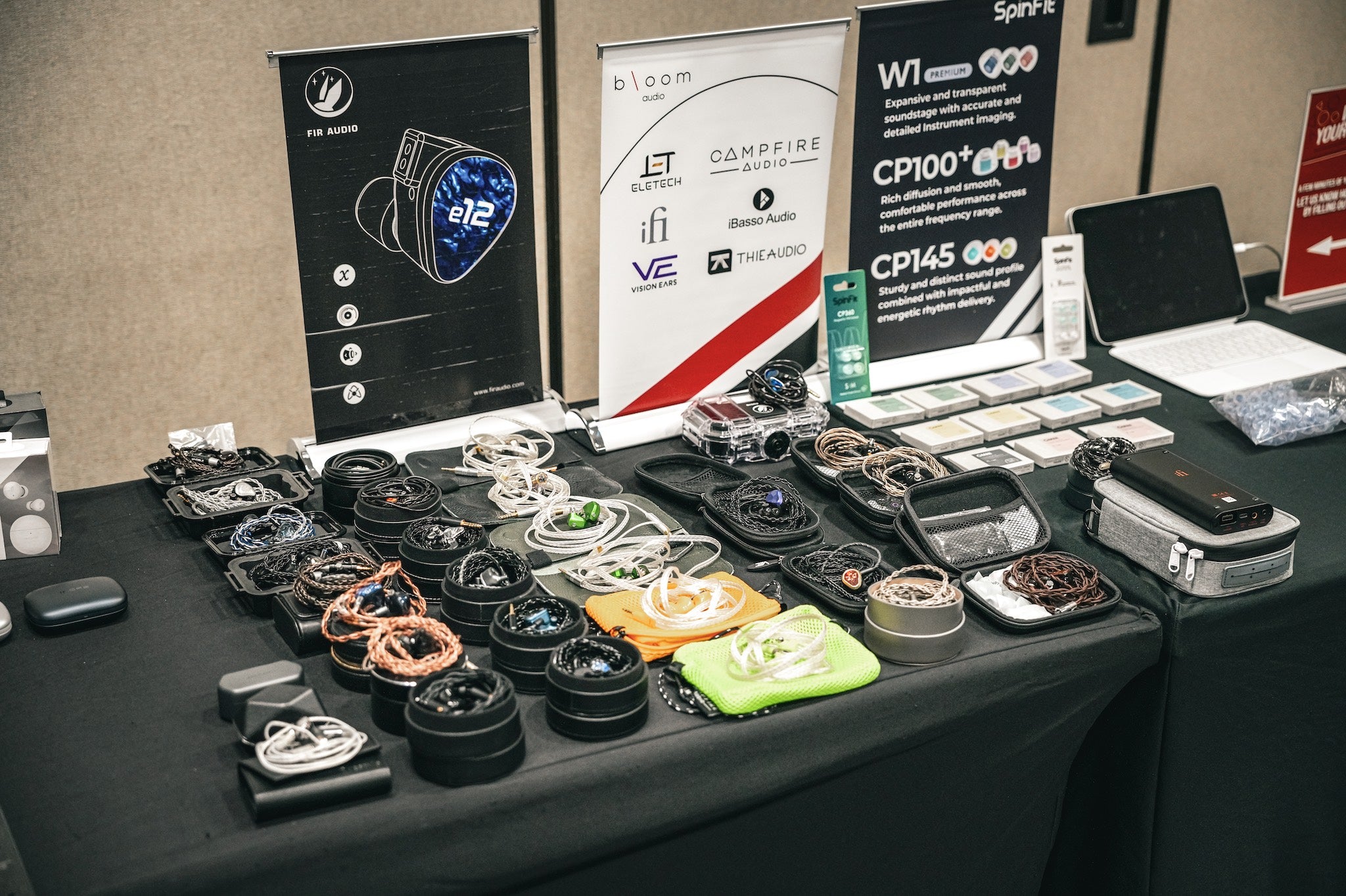 A wide selection of in ear monitors on a table for display and to listen to, from the Bloom Audio gallery