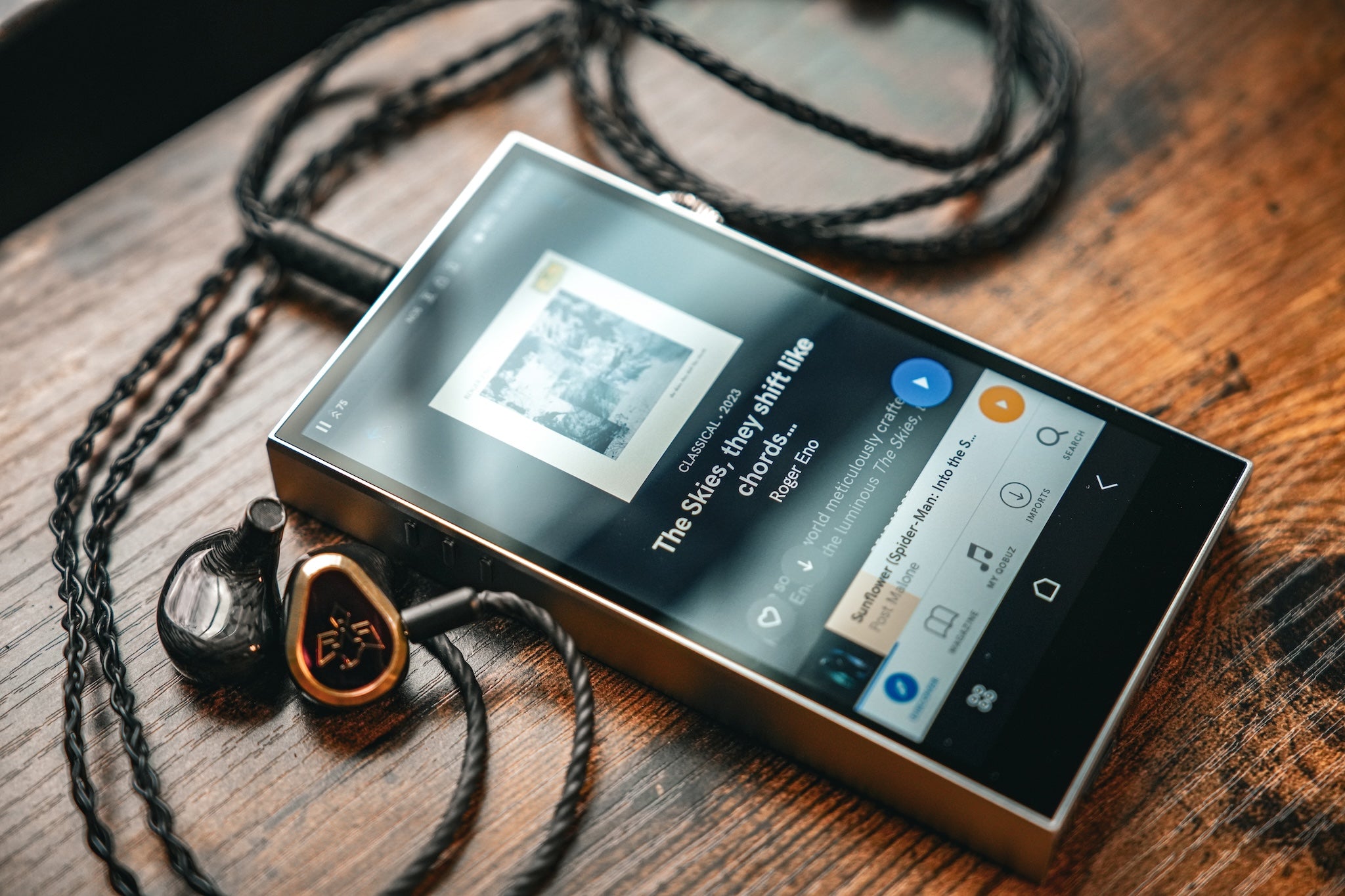 Astell&Kern SE300 front three quarter with connected Vision Ears earphones on wood table