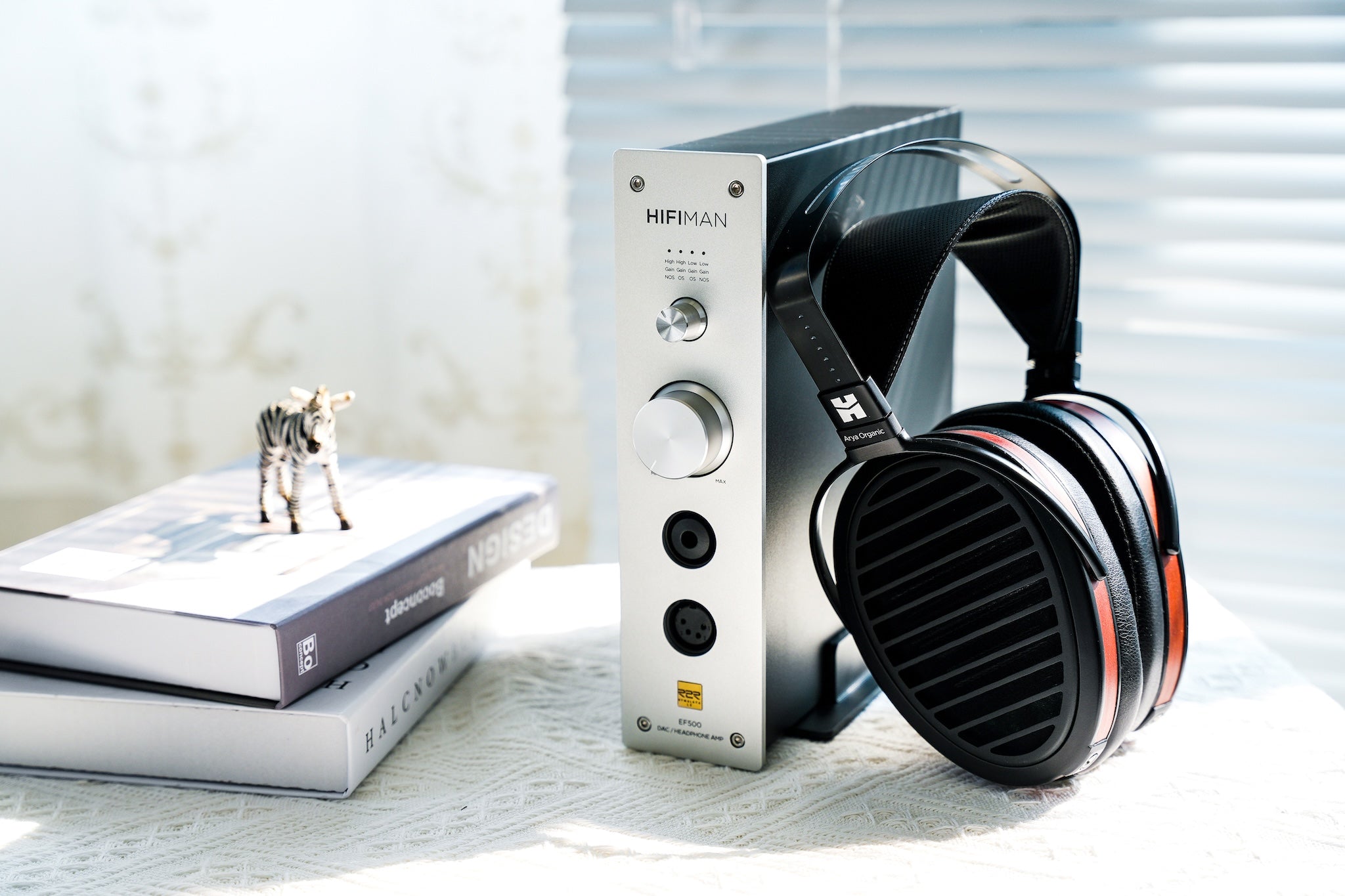 HiFiMAN EF500 DAC front right quarter with books and Arya headphones leaning on side in bright room