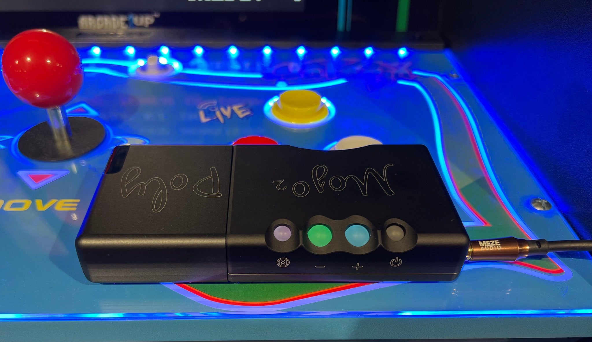 Chord Mojo 2 with attached Chord Poly streamer next to arcade cabinet controller