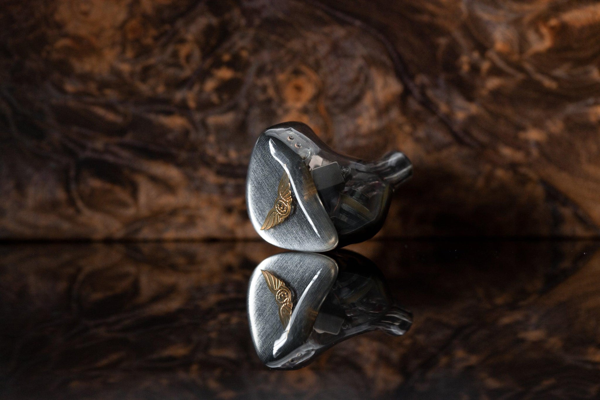 Empire Ears Legend X SE single IEM on brown reflective surface