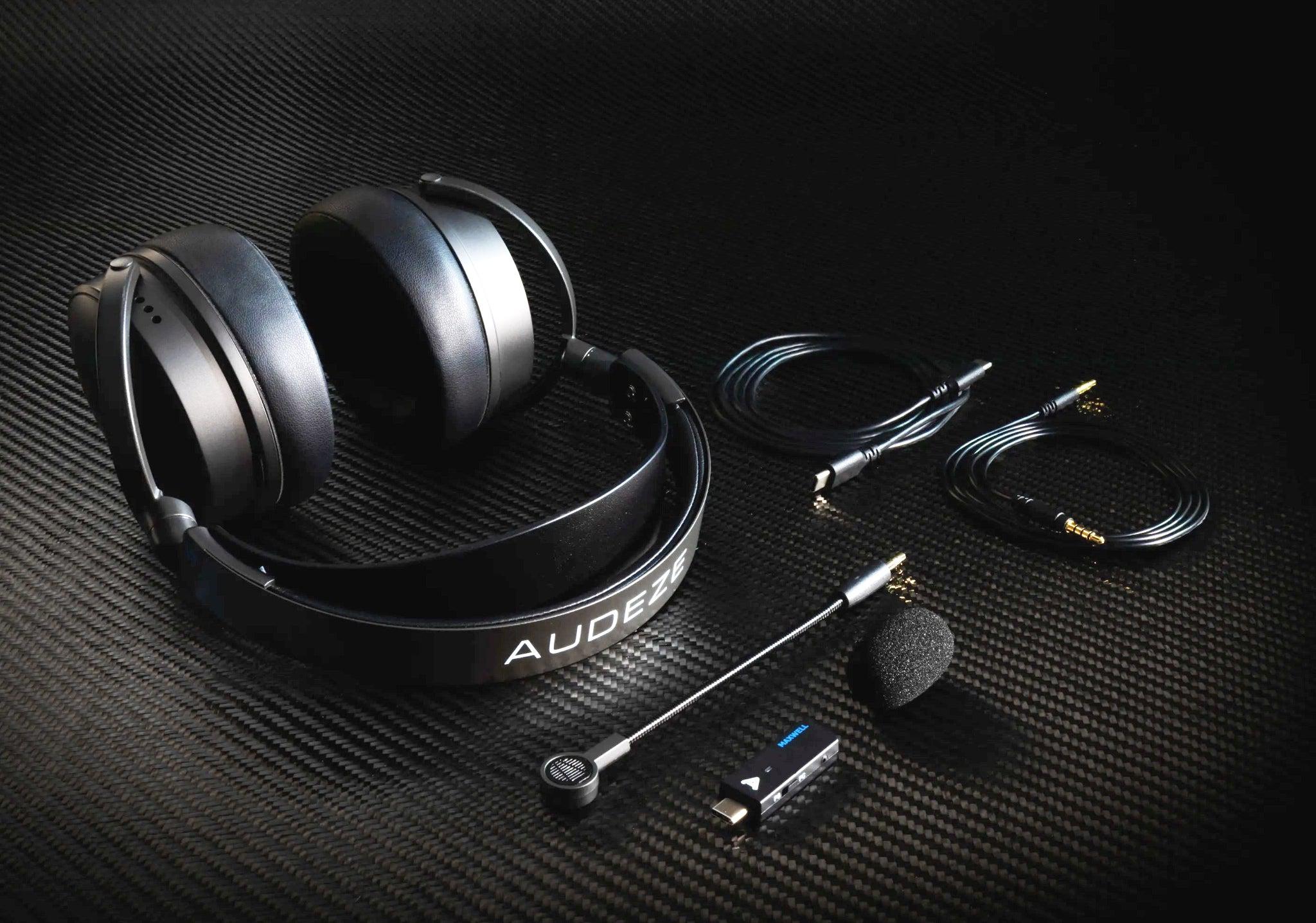 Audeze Maxwell headphones and all included accessories on dark metal surface