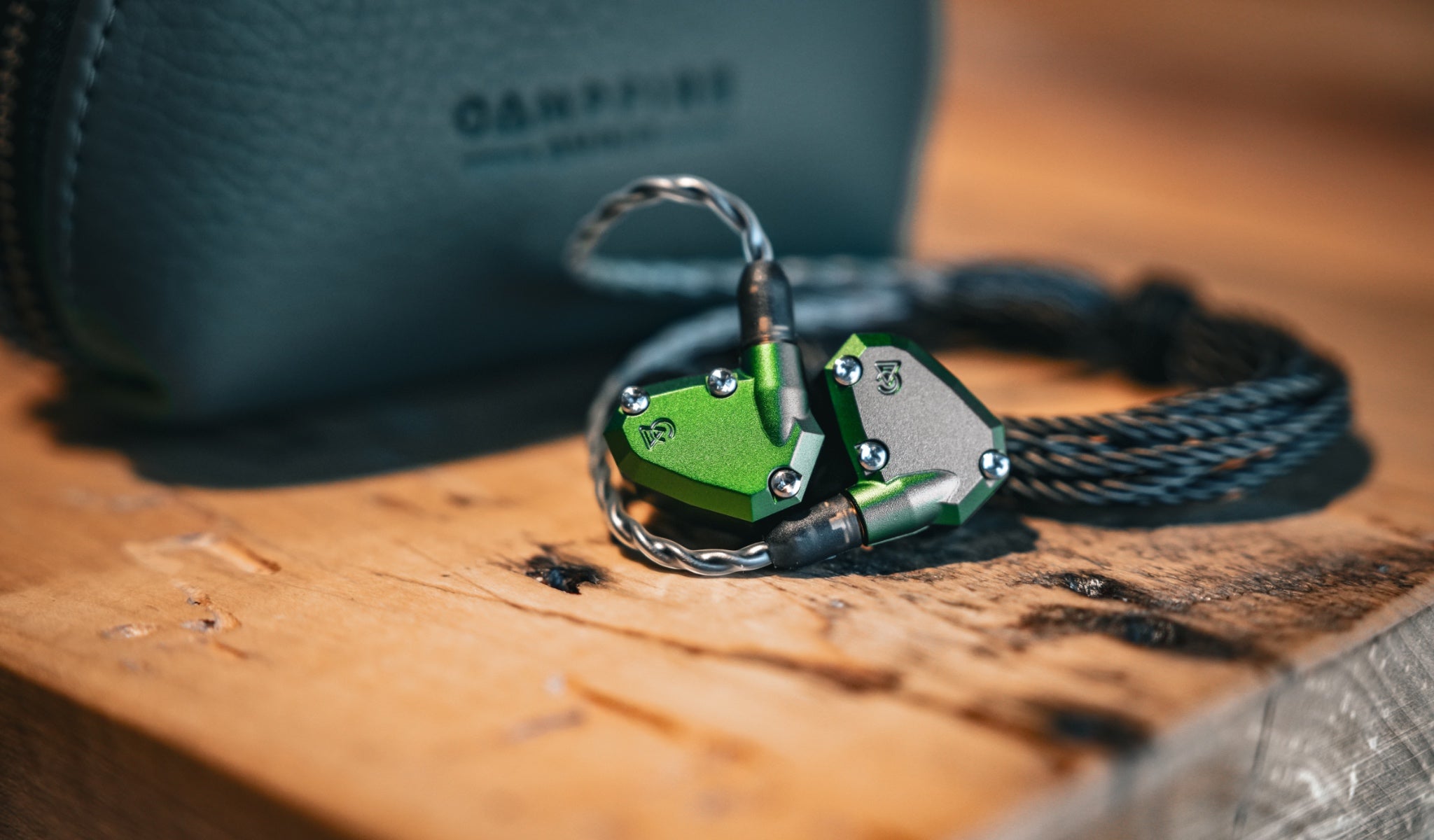 Campfire Audio Andromeda 2019 with attached stock cable and green case on butcher block table from Bloom Audio gallery