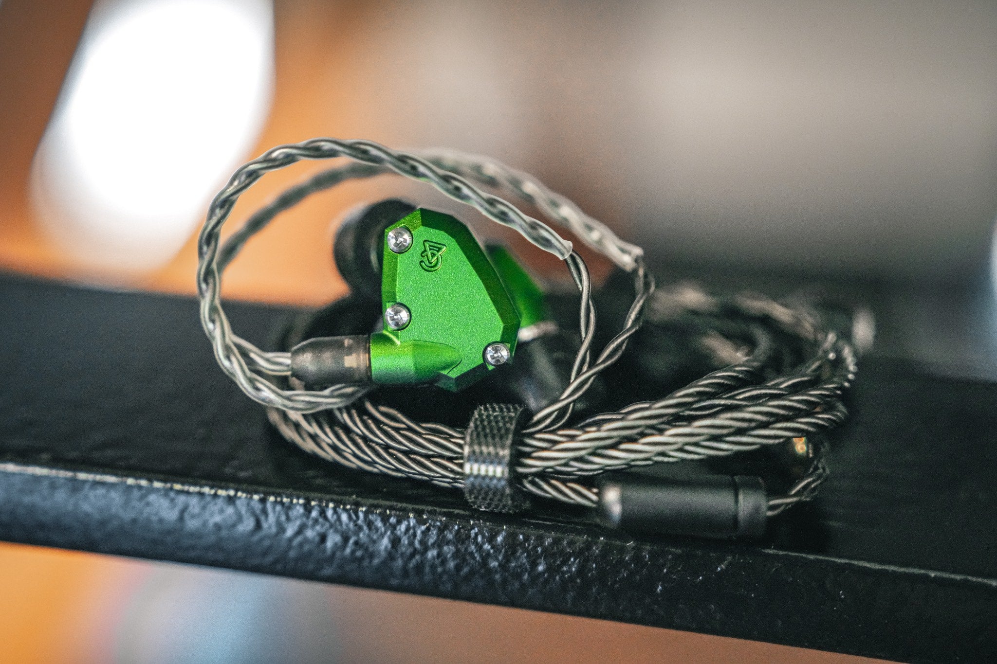 Campfire Audio Andromeda 2019 with attached coiled stock cable over black steel handrail from Bloom Audio gallery