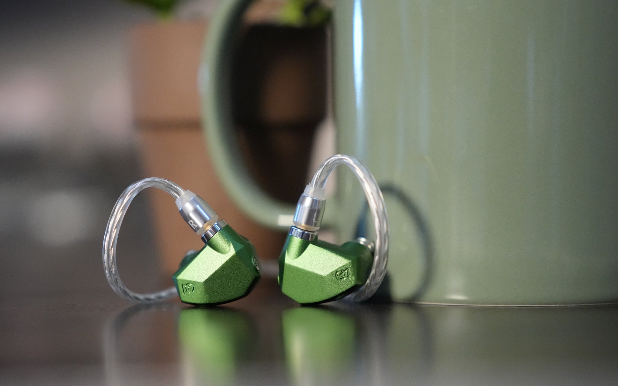 Campfire Audio Andromeda 2023 earphones with attached cables and green coffee mug