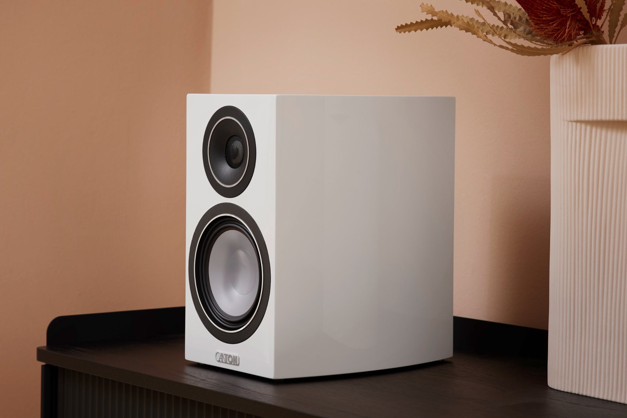 Canton Vento 20 white bookshelf speaker on table in peach color living space