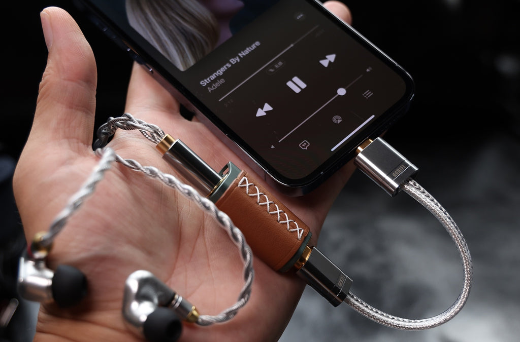 ddHiFi MFi09S cable connected to iPhone with DAC and earphones in a person's palm