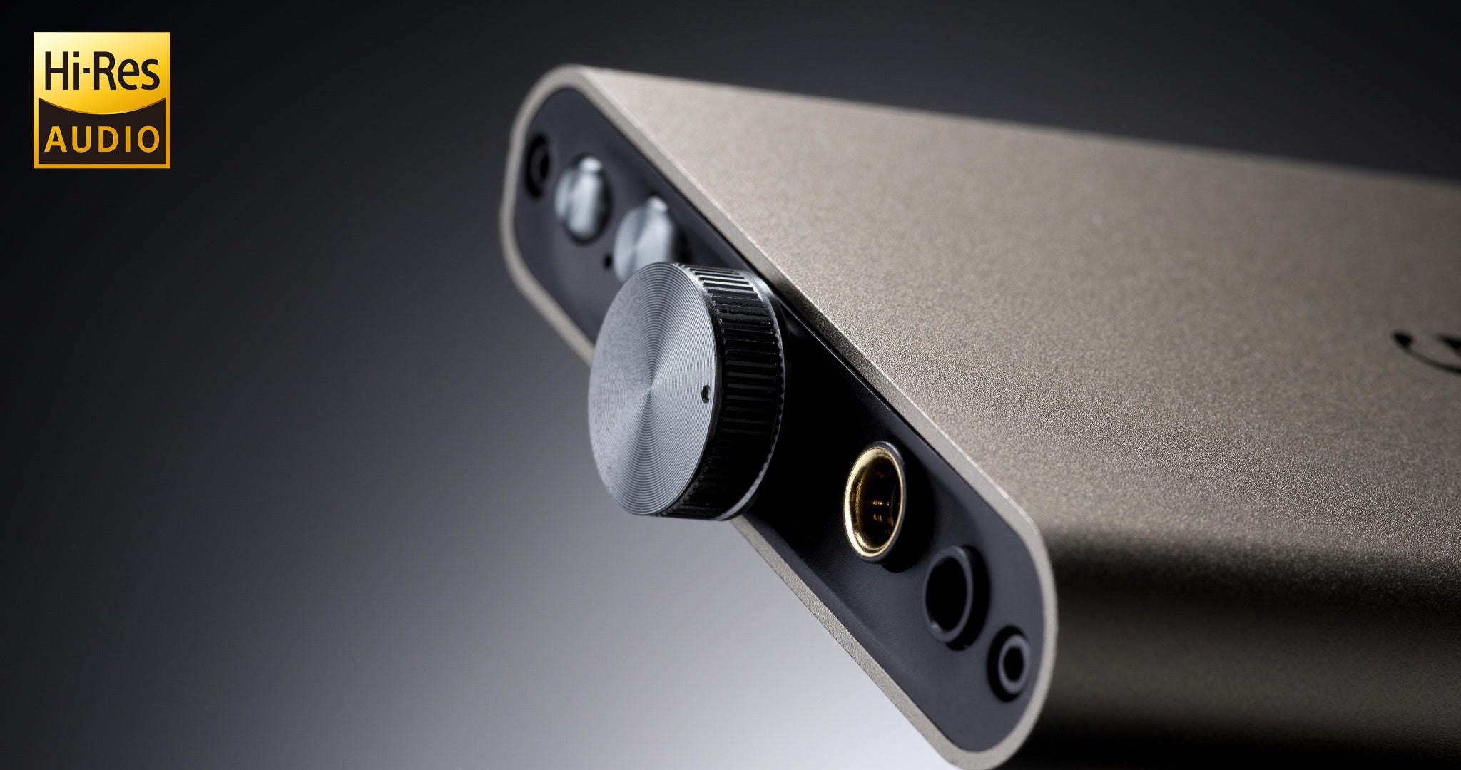 ifi hip-dac 3 dramatic closeup front volume knob and inputs over gray gradient with Hi-Res audio logo