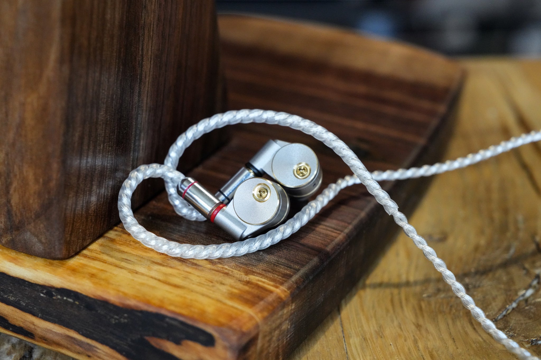 Ucotech RE-2 earphones on wood stand and table from Bloom gallery