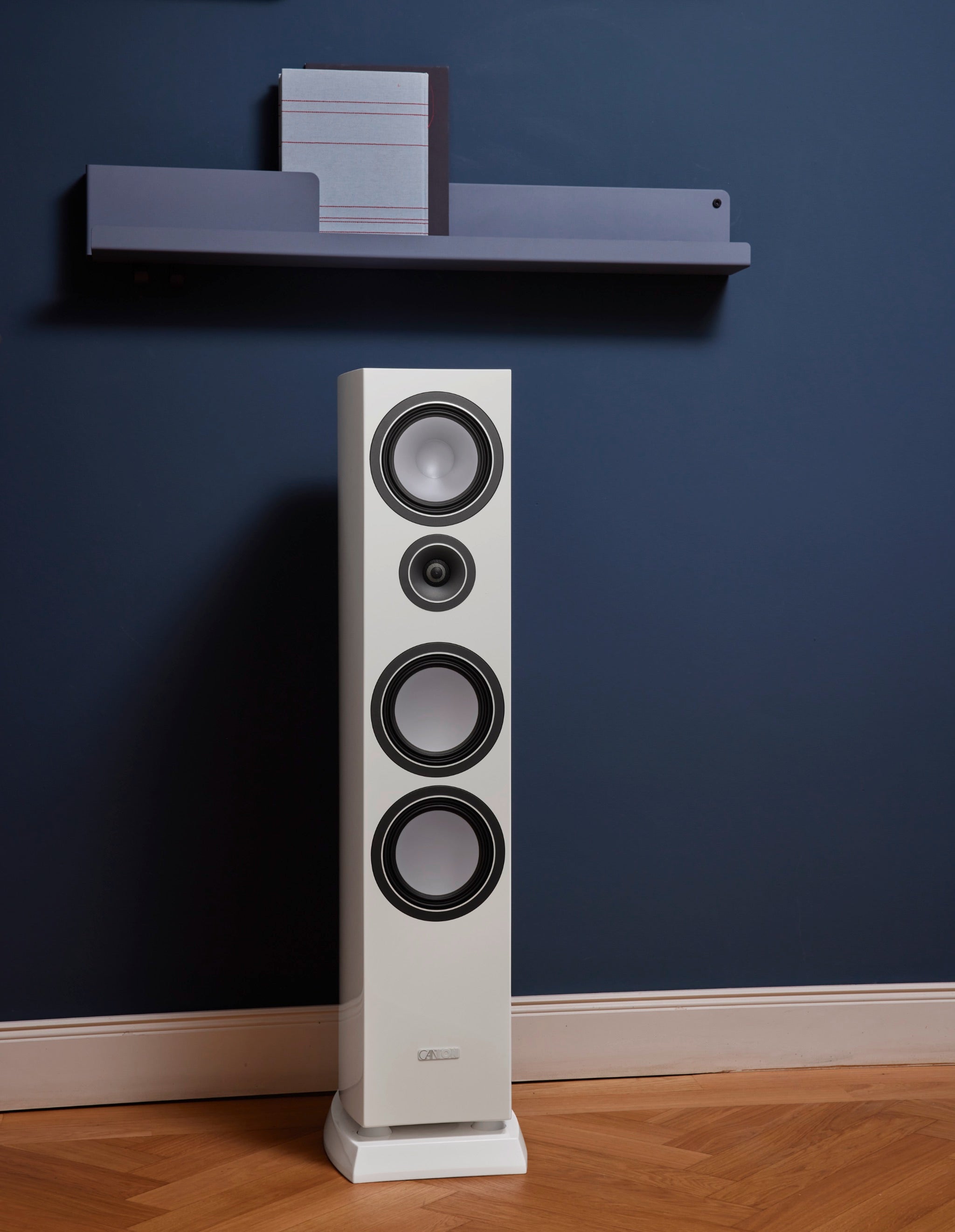 Canton Vento 80 white speaker in blue living space with shelf