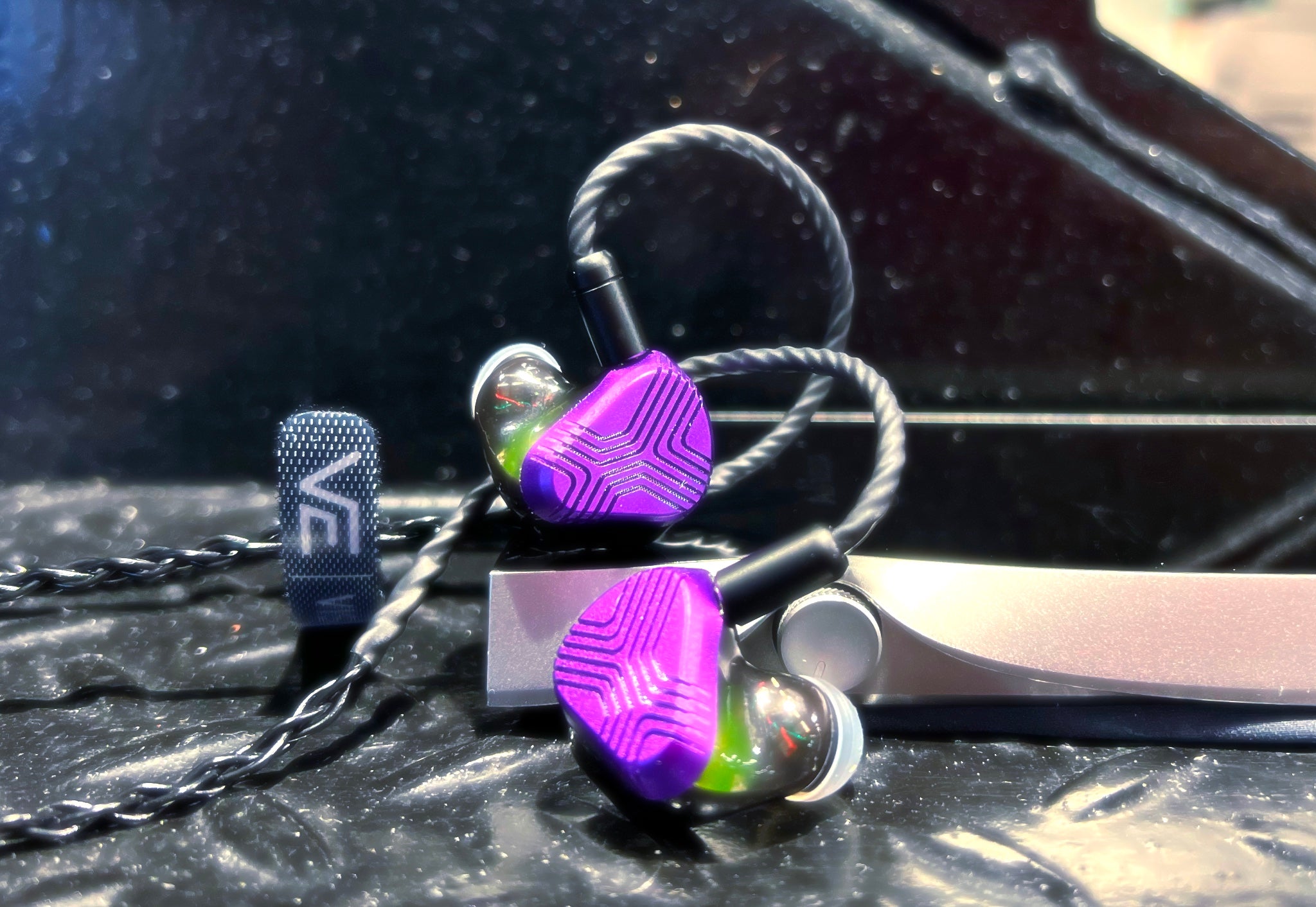 Vision Ears EXT earphone highlighting purple faceplate and internal drivers through transparent shell