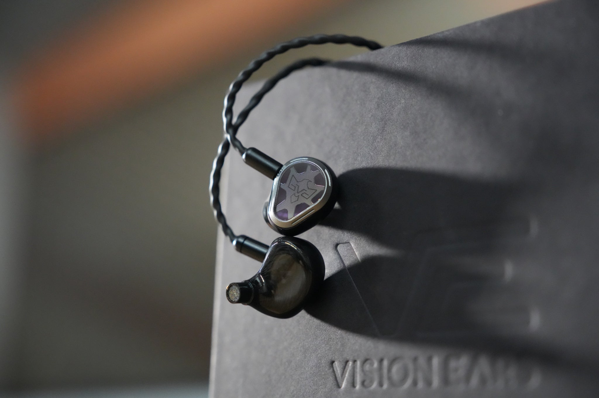 Vision Ears Phonix Limited with attached cable hanging over retail box