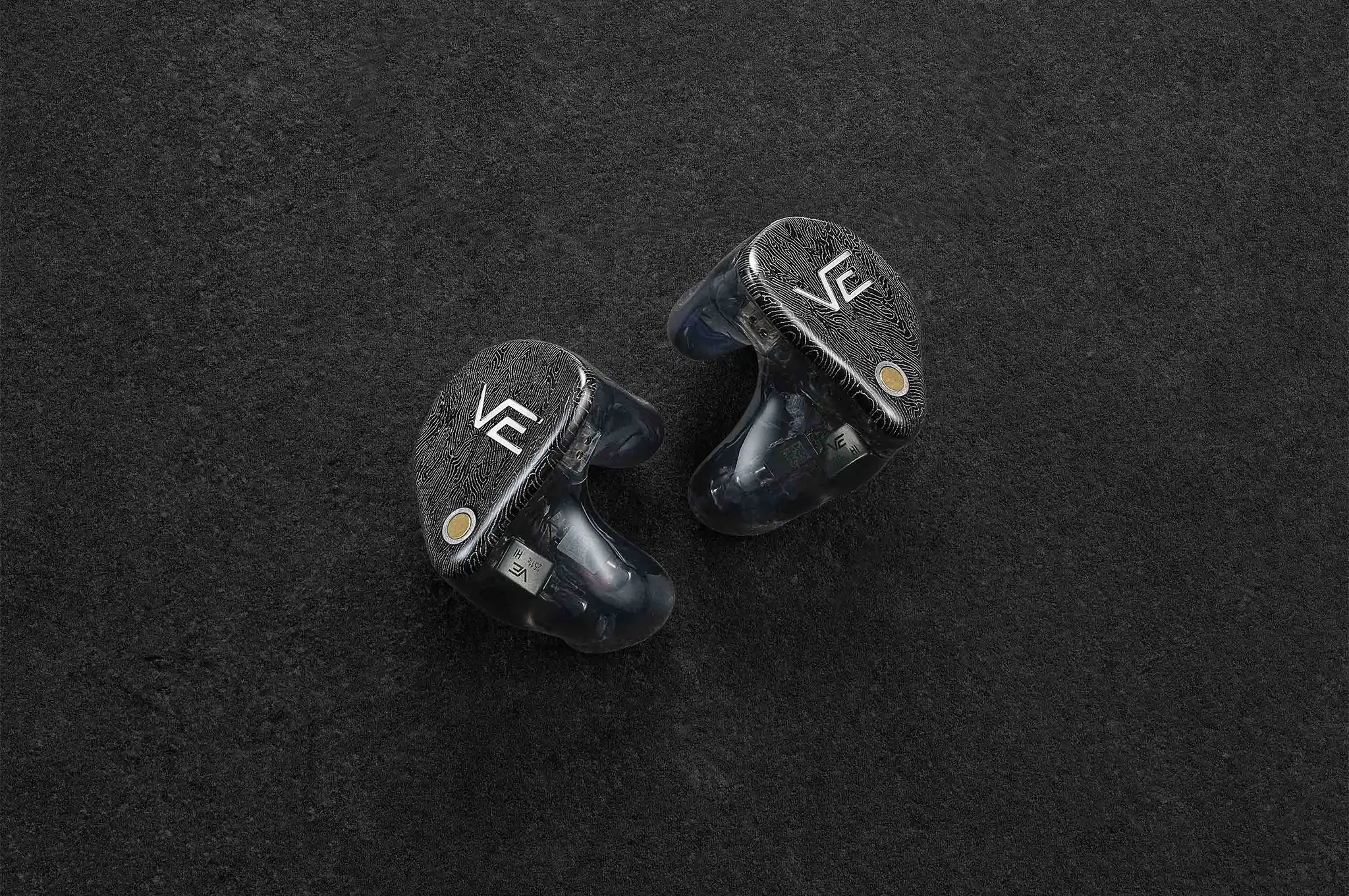 vision ears VE XCON IEMs sitting beside each other faceplate facing out on dark grey background