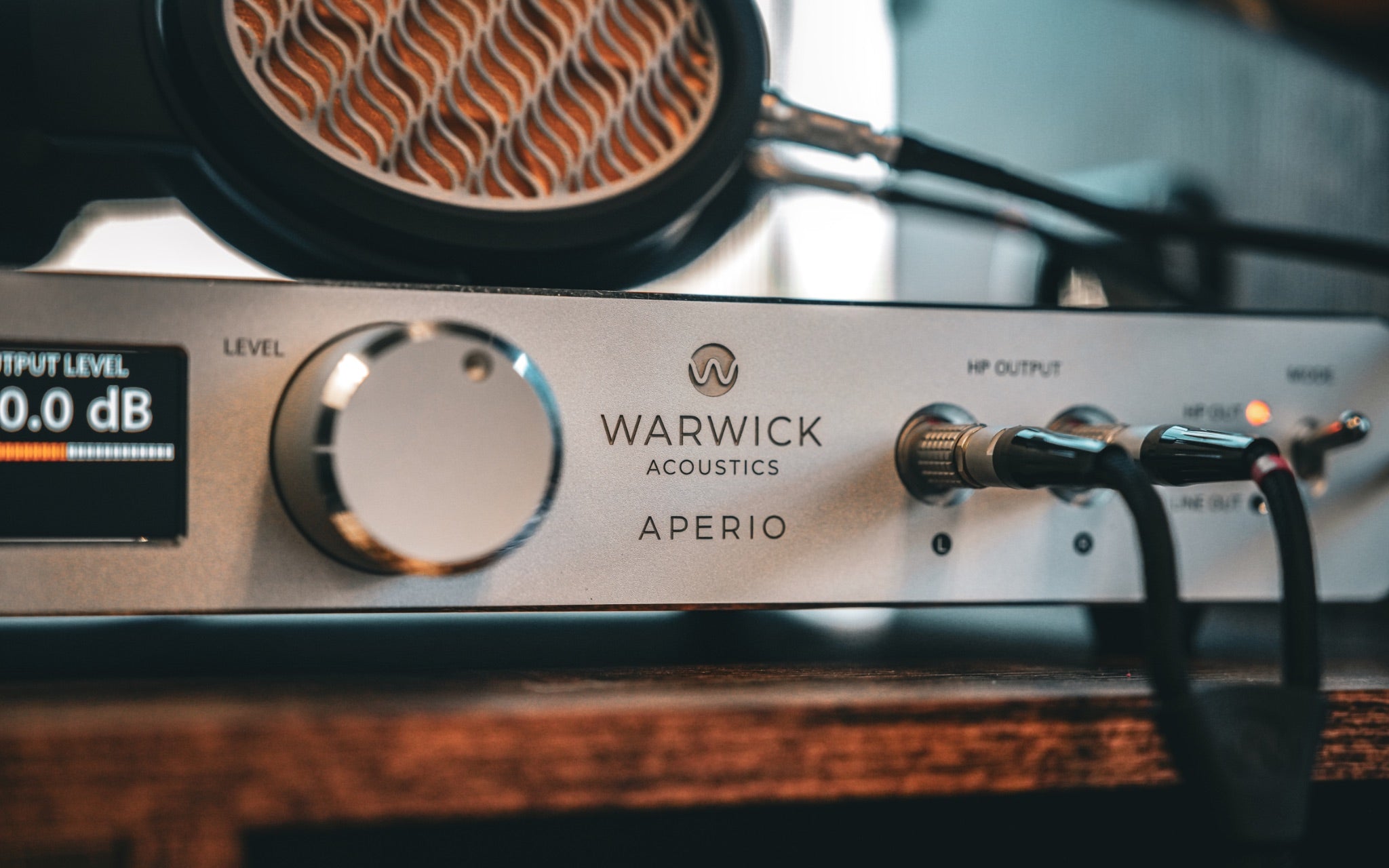 Warwick Aperio silver amp closeup highlighting logo, volume knob and headphone connectors