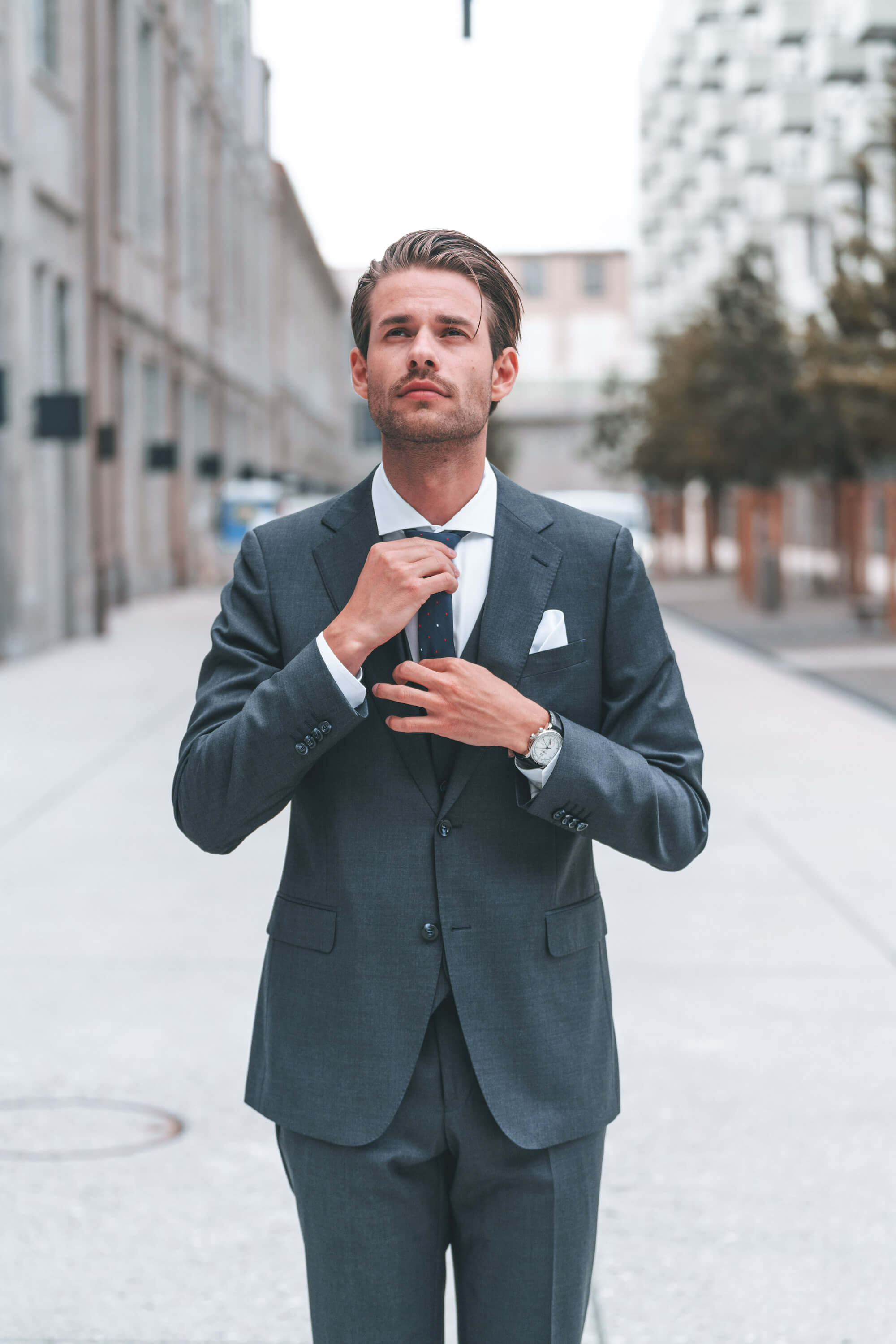 Young man in suit looks up