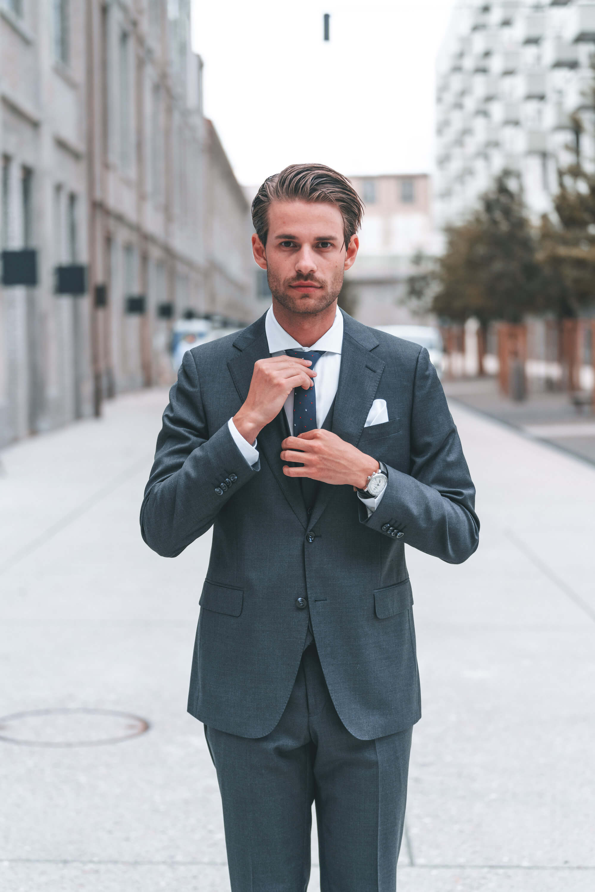 Junger Mann im grauen Anzug mit blauer Krawatte