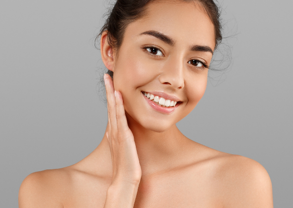  Girl looking at the camera, touching her face with glowing skin