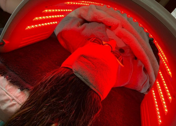 image of a woman using femvy led light therapy pod